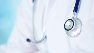 persona con una bata de médico blanca y un estetoscopio