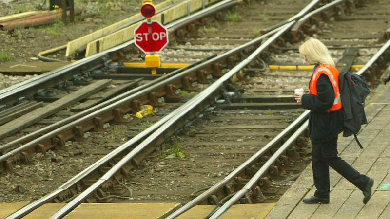 woman-walks-across-train-tracks