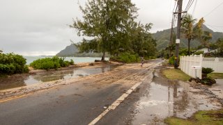 Sand and debris is left on Kamehameha Highway from high surf generated by Hurricane Douglas, Sunday, July 26, 2020, in Hauula, Hawaii. Hurricane Douglas came within “razor thin” distance of the Hawaiian Islands but spared the state the worst of the strong winds, storm surge and flooding officials had warned about.