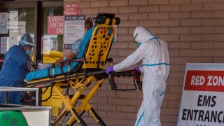 In this file photo, a patient is taken from an ambulance to the emergency room of a hospital.