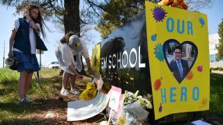 Sydney Monteith, left, and her mother Jennifer place the poster of Kendrick Castro on the STEM School Highlands Ranch. Students and parents car rally for one year memorial of STEM School Highlands Ranch shooting in Highlands Ranch, Colorado on Thursday. May 7, 2020.