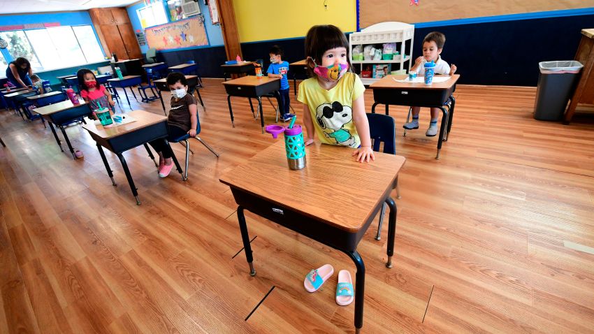 Children in a pre-school class wear masks and sit at desks spaced apart as per coronavirus guidelines during summer school sessions in Monterey Park, California on July 9, 2020. - California Governor Gavin Newsom says the reopening of California schools for the coming school year will be based on safety and not pressure from President Donald Trump as California sets records for one-day increases in COVID-19 cases.