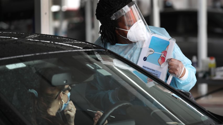 A health care worker uses a picture to show a person how to use a nasal swab for a self administered test at the new federally funded COVID-19 testing site at the Miami-Dade County Auditorium on July 23, 2020 in Miami, Florida. Vice Admiral Jerome Adams, the U.S. Surgeon General, visited the site, as the state of Florida experiences a spike in coronavirus cases, to encourage people to wear a mask and take other precautions to fight the pandemic.