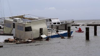 John Nolan uses his kayak to survey the damage to a private marina after it was hit by Hurricane Hanna, Sunday, July 26, 2020, in Corpus Christi, Texas.