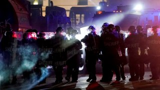 authorities disperse people from a park in Kenosha, Wis