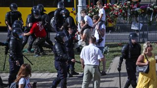 Riot police detain a man participating in a memorial event for a person killed in a clash with law enforcement officers during a protest against the results of the 2020 Belarusian presidential election