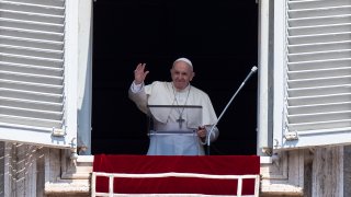 Pope Francis waves at faithfuls from the window of the apostolic palace overlooking St.Peter's square during his Angelus prayer on August 15, 2020 at the Vatican.