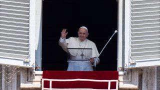 Pope Francis waves at faithfuls from the window of the apostolic palace overlooking St.Peter's square during his Angelus prayer on August 15, 2020 at the Vatican.