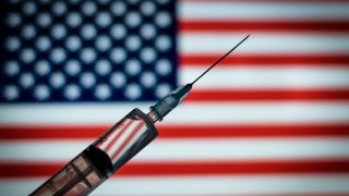 Photo illustration of the medical syringe is seen with the Usa flag in the background on August 18, 2020 in Rome, Italy.
