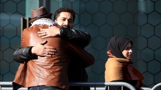 Survivors and family members of the 2019 twin mosque shootings greet each other outside the High Court building on the last day of the sentencing hearing for Brenton Tarrant, the gunman who massacred 51 people during the attacks, in Christchurch on August 27, 2020.