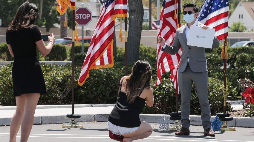 Duc Tran, originally from Vietnam, poses for photos after being sworn in as a new U.S. citizen from his vehicle at a drive-in naturalization ceremony amid the COVID-19 pandemic on July 29, 2020 in Santa Ana, California.