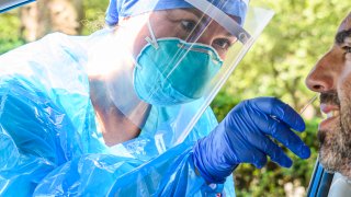In this July 29, 2020, file photo, a health worker wears a protective face mask, face shield and gloves while performing a COVID-19 nasal swab test on a friend of the photographer on the Upper West Side as the city continues Phase 4 of re-opening following restrictions imposed to slow the spread of coronavirus in New York City.