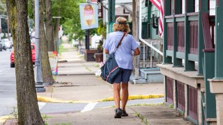 United States Postal Service letter carrier walks her route