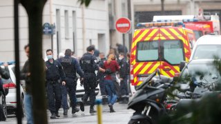 French police officers patrol the area after a knife attack near the former offices of satirical newspaper Charlie Hebdo
