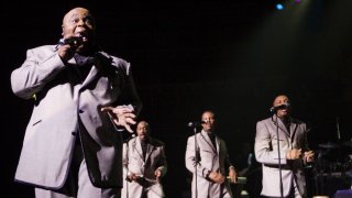 In this file photo, (L-R) Bruce Williamson, Otis Williams, Terry Weeks and Ron Tyson of the Temptations perform on stage at Royal Albert Hall in London, England.