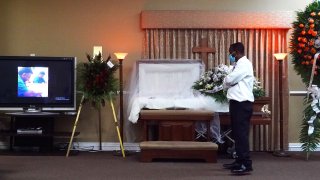 Joseph Louis pays his respects to German Amaya, who he worked with for 10 years, as family and friends held a wake ceremony at the Maspons Funeral Home in Miami, Florida