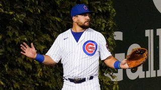 Kyle Schwarber holds up his hands after losing a ball in the ivy at Wrigley Field