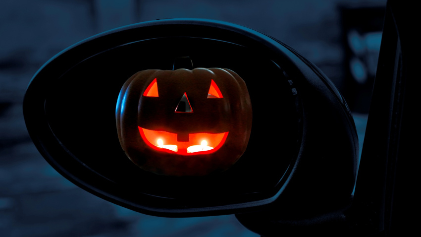 Jack-o’-Lantern seen in rearviewmirror of a car