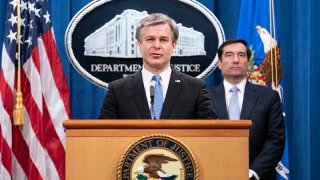 FBI Director Christopher Wray speaks during a virtual news conference at the Department of Justice, Oct. 28, 2020, in Washington, as Assistant Attorney General for National Security John Demers looks on.