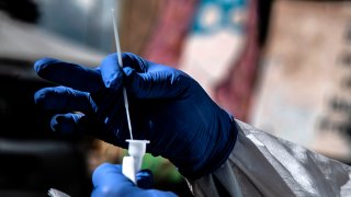 A medical worker prepares for drive-through COVID-19 tests outside the Santa Maria della Pieta' hospital in Rome, Oct. 12, 2020.