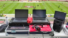 Two laptops in a road case sit on a balcony overlooking the 49ers' football field at Levi's Stadium.