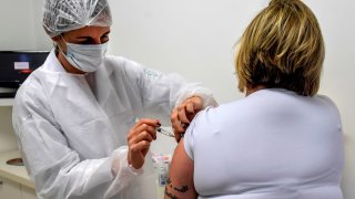 In this July 2020, file photo, a Brazilian doctor voluntarily receives an injection as part of phase 3 trials of a vaccine developed by the University of Oxford and British pharmaceutical company AstraZeneca.