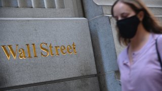 People walk by the New York Stock Exchange (NYSE) in lower Manhattan on October 5, 2020 in New York City.