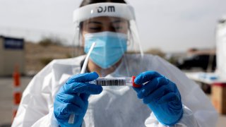 A medical personnel administers a free Covid-19 tests at a state run drive-through testing site in the parking lot of the University of Texas El Paso campus amid the coronavirus disease (COVID-19) outbreak, in El Paso, Texas, November 23, 2020.
