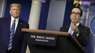 U.S. President Donald Trump, left, listens as Steven Mnuchin, U.S. Treasury secretary speaks during a news conference at the White House in Washington D.C., U.S. on Tuesday, April 21, 2020. The Trump administration vowed to stem job losses and rescue the oil industry with stimulus funds and other measures as the U.S. responds to a global glut in crude thats led to an historic rout in prices.