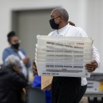 A worker with the Detroit Department of Elections carries empty boxes used to organize absentee ballots after nearing the end of the absentee ballot count at the Central Counting Board in the TCF Center on November 4, 2020 in Detroit, Michigan.