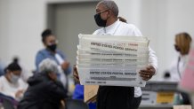 A worker with the Detroit Department of Elections carries empty boxes used to organize absentee ballots after nearing the end of the absentee ballot count at the Central Counting Board in the TCF Center on November 4, 2020 in Detroit, Michigan.