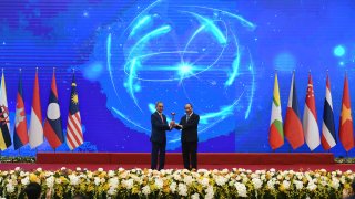 Vietnam's Prime Minister Nguyen Xuan Phuc (R) hands over the ASEAN gavel, a symbol of Association of Southeast Asian Nations (ASEAN) chairmanship, to Brunei's ambassador to Vietnam Pengiran Haji Sahari Bin Pengiran Salleh (L) during the closing ceremony of ASEAN summit being held online in Hanoi on November 15, 2020.