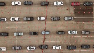 This aerial view shows people waiting in line in their cars at a Covid-19 testing site at Dodger Stadium