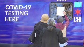 In this Nov. 12, 2020, file photo, residents check in for a COVID-19 test at a test site run by CORE at St. Benedict the African Catholic Church in the Englewood neighborhood in Chicago, Illinois.