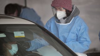 A worker tests a resident at a drive-up COVID-19 test site on November 13, 2020 in Aurora, Illinois.