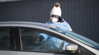 A worker tests a resident at a drive-up COVID-19 test site on November 13, 2020 in Aurora, Illinois.