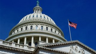 In this file photo, the stars and stripes flag flies at the Capitol Building in Washington, D.C.