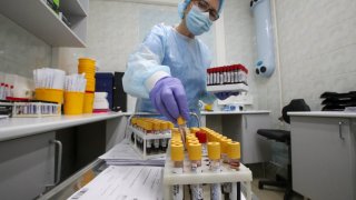 A healthcare worker performs laboratory tests.