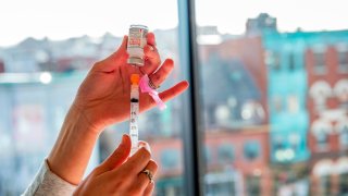 A nurse prepares a syringe with the Moderna vaccine at the East Boston Neighborhood Health Center (EBNHC) in Boston, Massachusetts on December 24, 2020.