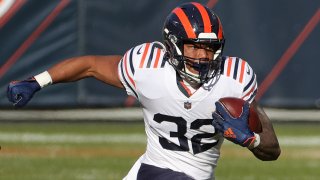 Bears running back David Montgomery, wearing the team's throwback 1930's era white jerseys with orange and blue shoulder stripes, runs down the field against the Houston Texans