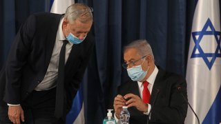 Israeli Prime Minister Benjamin Netanyahu (R) speaks with Alternate PM and Defence Minister Benny Gantz, both wearing protective mask due to the ongoing COVID-19 pandemic, during the weekly cabinet meeting in Jerusalem on June 7, 2020. - Netanyahu urged world powers to reimpose tough sanctions against Iran, vowing to curb Tehran's regional "aggression" hours after another deadly strike on pro-Iranian fighters in Syria. (Photo by Menahem KAHANA / AFP)