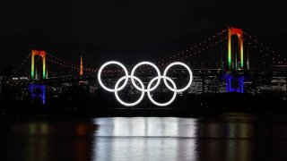 In this Dec. 1, 2020, file photo, the illuminated Olympic rings, Rainbow Bridge and Tokyo Tower are seen at Tokyo Bay area, in Tokyo, Japan.