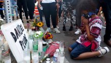 Hasan Massey Jr., 11, kneels in prayer at a make-shift memorial at the site where Daniel Prude was arrested on Sept. 3, 2020, in Rochester, New York. Prude died after being arrested by Rochester police officers who had placed a "spit hood" over his head and pinned him to the ground while restraining him.