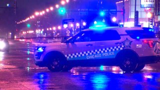 A Chicago police SUV blocks traffic on a rain-soaked street late Friday night after an officer-involved shooting