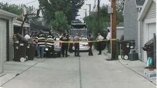 Authorities examine the scene where the bodies of two young boys were found after a 2003 murder in Stickney