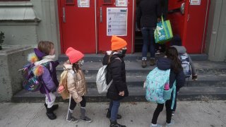 Children line up to attend class at PS 361 on the first day of a return to class during the coronavirus disease (COVID-19) pandemic in the Manhattan borough of New York City, New York, U.S., December 7, 2020.