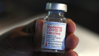 A medical worker holds a Moderna COVID-19 vaccine vial