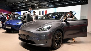 People look at a Tesla Model Y car at a Tesla showroom in Beijing on January 5, 2021.