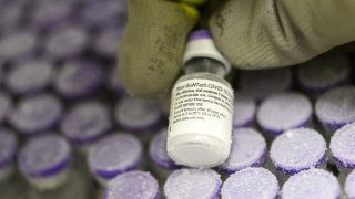 This January 15, 2021, photo shows a pharmacist holding with gloved hands a phial of the undiluted Pfizer-BioNTech vaccine for COVID-19, stored at -70 ° in a super freezer of the hospital of Le Mans, northwestern France.