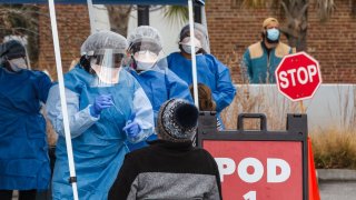 In this Jan. 13, 2021, file photo, healthcare workers from the Medical University of South Carolina administer free COVID-19 tests at a site in a parking lot between Edmund's Oast and Butcher & Bee restaurants in Charleston, South Carolina.
